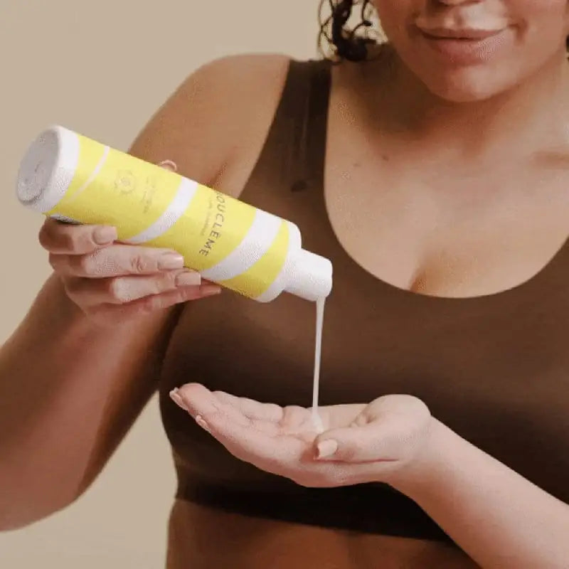 Woman applying curly hair product from yellow bottle into hand