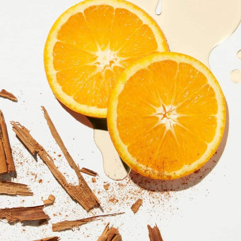 Fresh orange slices with cinnamon sticks and creamy sauce, vibrant citrus and spice on white background