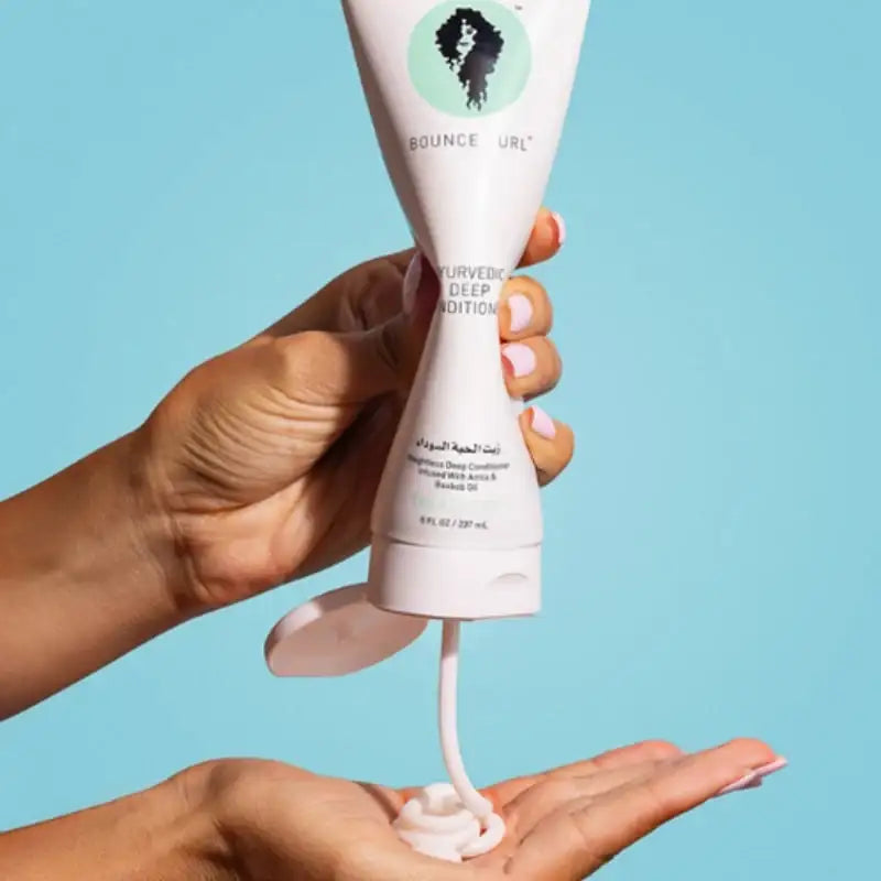 Bounce Curl Ayurvedic Deep Conditioner being squeezed into hand for curly hair care routine